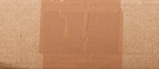 Surface of plain cardboard box with transparent plastic covering 