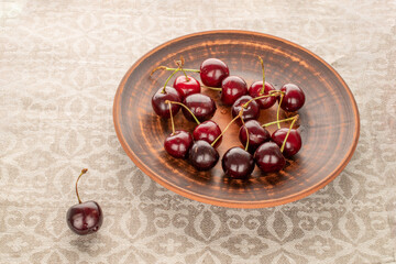 Sweet cherries on a clay plate, macro.