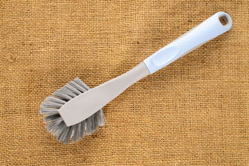 One dishwashing brush on a jute cloth, top view.