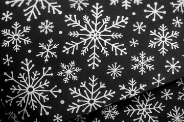 Riga, Latvia 05-09-2024 A close-up of a black fabric adorned with white snowflakes, evoking the chill and beauty of a snowy day
