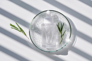 A clear bottle of serum in a petri dish. A sample of the texture of the product.
