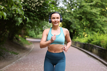Sporty woman with headphones running in park