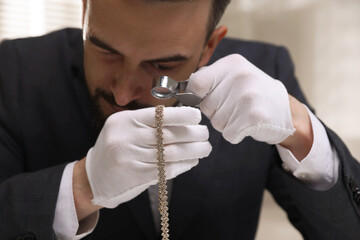 Appraiser evaluating luxury necklace indoors, closeup view