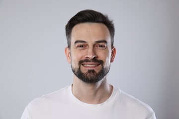 Obraz premium Portrait of smiling man on grey background, closeup