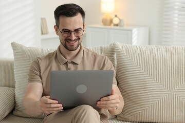 Professional psychologist having online consultation with his client via laptop on sofa indoors