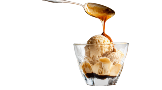 A scoop of creamy ice cream topped with a drizzle of caramel sauce in a clear glass bowl.