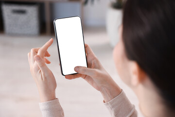 Woman using modern smartphone at home, closeup
