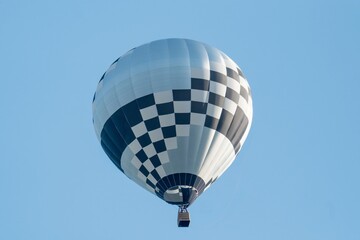 Black and white hot air balloon flying in the blue sky
