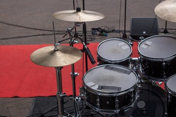 Drum set placed on red carpet, ready for a live concert