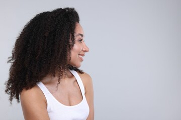 Beautiful Brazilian woman with healthy skin on gray background. Space for text