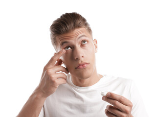 Man putting in contact lenses on white background