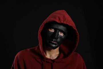 Anonymity. Man wearing mask on dark background