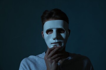 Anonymity. Man wearing mask on blue background