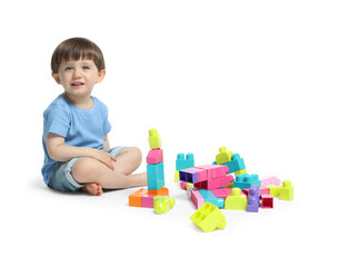 Cute little boy playing with building bricks on white background
