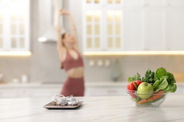 Slim woman in sportswear posing indoors, focus on kitchen scale, healthy food, and measuring tape