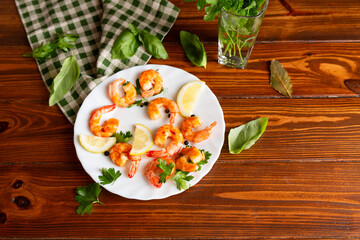 Appetizing seafood in a plate on a wooden, with lemon and herbs