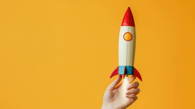 A person holds a toy rocket in their hand, ready for blast off