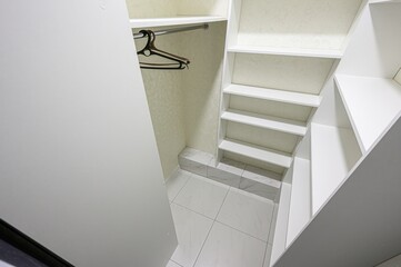 organized, walk-in closet space is shown with white shelving and a hanger. The interior design...