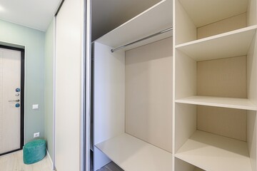bright hallway with a sliding door wardrobe, showing shelves and a hanging rod. The interior...