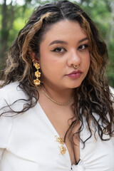 Fashion model posing with golden jewelry and stylish white outfit