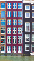 Obraz premium Holland, Amsterdam Damrak canal houses with scenic bridges in historic center, UNESCO Heritage site