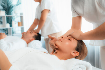 Caucasian couple enjoying relaxing anti-stress head massage and pampering facial beauty skin...