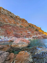 Red Rocky Cliffs and Turquoise Sea in Sutomore, Montenegro on a Hot Summer Day