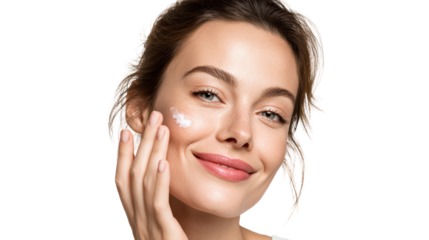 A woman applying cream on her face, showcasing a radiant smile and healthy skin.