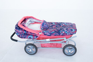 Pink toy stroller on a white background