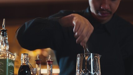 Closeup hand bartender holding jigger to measure liquor sugar into mixing glass ingredients alcohol...