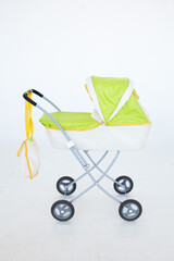 Toy green stroller on a white background