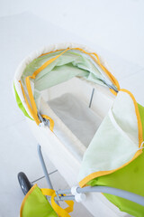 Toy green stroller on a white background