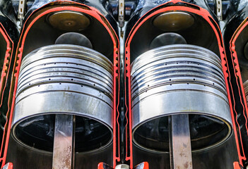 Engine components showing pistons inside the cylinder head with intricate details at a mechanic...