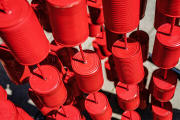 Bright red decorative cans hanging in a festive outdoor setting showcasing creativity and vibrant...
