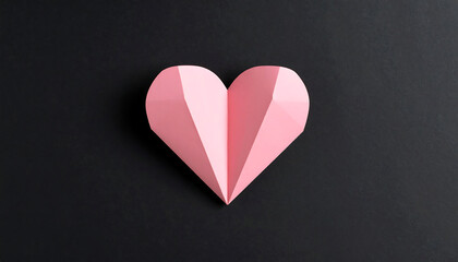 Obraz premium Pink origami heart rests elegantly on dark surface, casting soft shadow that enhances its delicate features and adds depth to composition