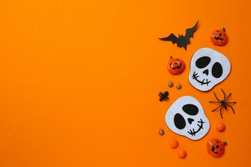 Halloween festive background design featuring bat, skulls, spiders and confetti