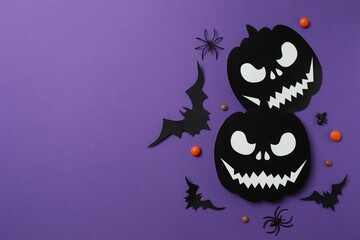 Halloween festive background design featuring black pumpkins, bats, spiders and confetti. Top view,...
