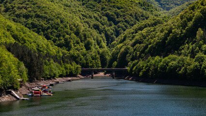 Bridge over Tarnita Lake with forested shoreline in Romania