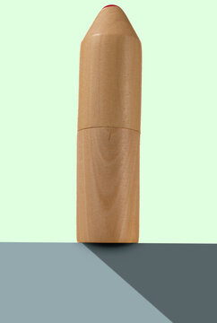 wooden pencil case on a pastel mint background, staying on grey elevation.