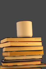 stack of books with cup of coffee on top, isolated on dark grey background