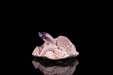 Amethyst, on microcline. Specimen from Erongo region, Namibia. photography isolated on black background. macro detail close-up mineral crystal unpolished semi-precious gemstone