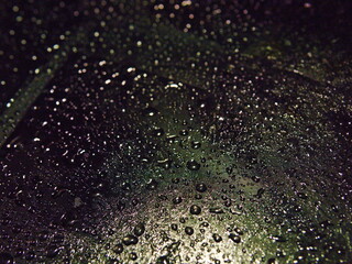 Complex texture of many droplets on black with dim light. Closeup