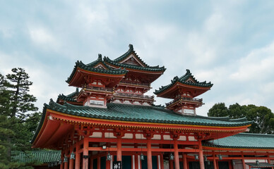 The ornate, multi-tiered roof of Heian Shrine displays intricate traditional Japanese architectural details, with its vibrant red and green colors highlighting the fine craftsmanship in Kyoto, Japan.