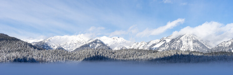 Obraz premium A mountain range with snow on the peaks and a blue sky