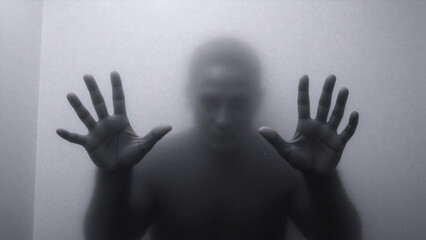 A man standing in front of a glass door with his hands outstretched.