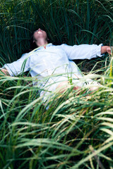 Portrait, rest and a woman lying on grass outdoor in nature during summer for peace or quiet on a field. Spring, garden and relax with a young person relaxing outside on green ground in a countryside