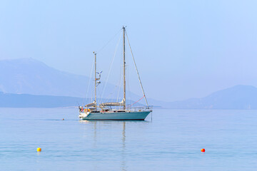 Fototapeta premium Peaceful Sailboat on Calm Blue Sea