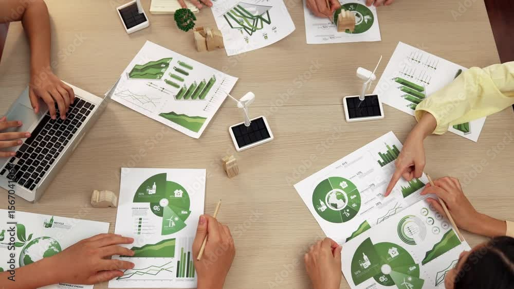 Poster excellent business team discussing on eco house project at meeting table with windmill design model 