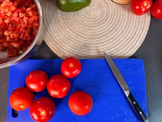Sliced Roma Tomatoes on a Wooden Cutting Boar Slices of fresh plum tomatoes with eggs, basil, and a...