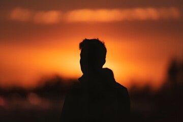 Fototapeta premium Silhouette of a Man Against a Fiery Sunset A Captivating Image
